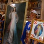 During a break in talks on Thursday, Bridget Anyaegbuma, right, and Mary Therisa Onyeji, from the United Kingdom, pose by the image of The Divine Mercy in the Basilica of St. John Lateran in Rome.